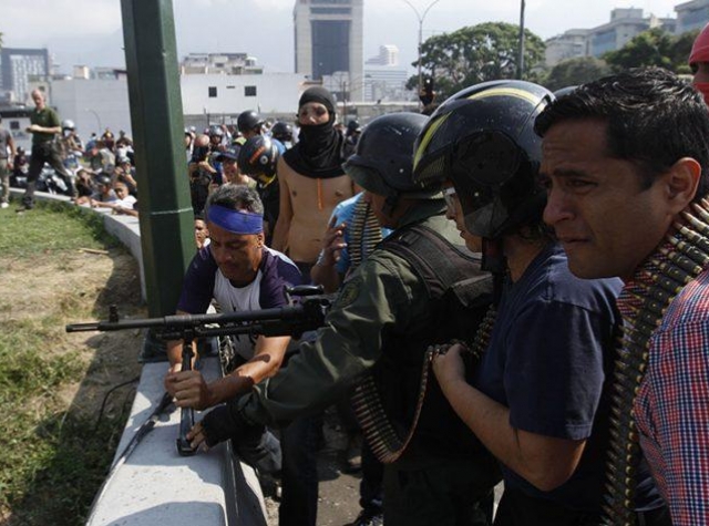 Foto: https://www.laiguana.tv/ En håndfull soldater som støtter opposisjonen forbereder voldelige handlinger i Caracas tirsdag 30. april